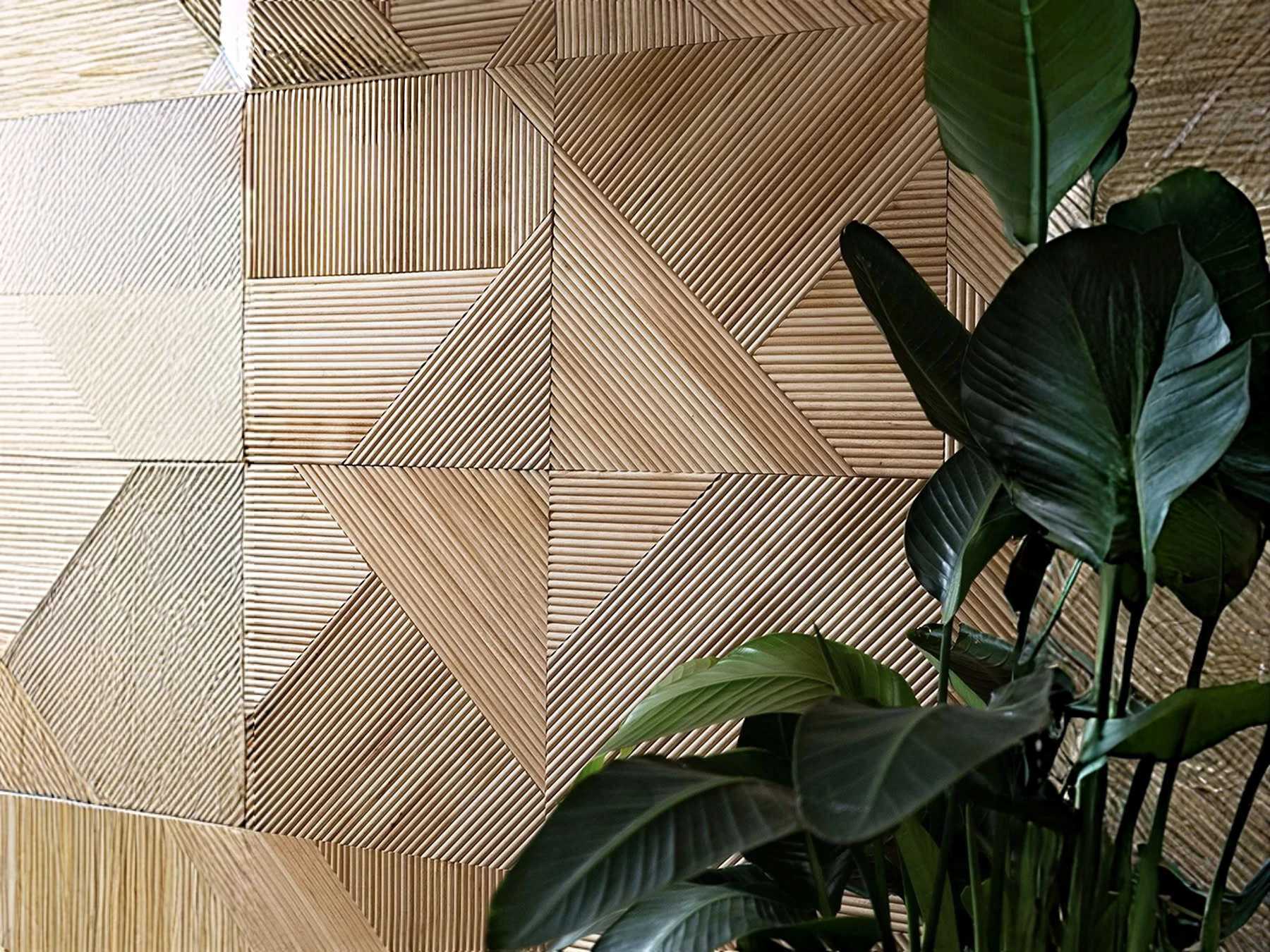 Stylish wooden wall paneling with a modern geometric pattern and green plant accent.